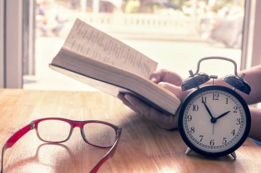 Masada kitap okumak. Retro çalar saat üzerinde odaklanın. Zaman okumak için 