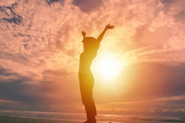 Šťastná žena pozvedá ruce a krásný východ slunce v pozadí — Stock fotografie
