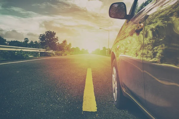 Gündoğumu, yolda araba. Vintage renk stili.