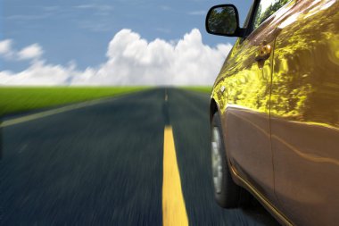 Turuncu araba sürüş hızlı yolda.