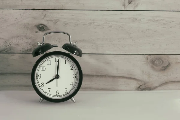 Retro çalar saat beyaz plaka ve ahşap arka planda. 
