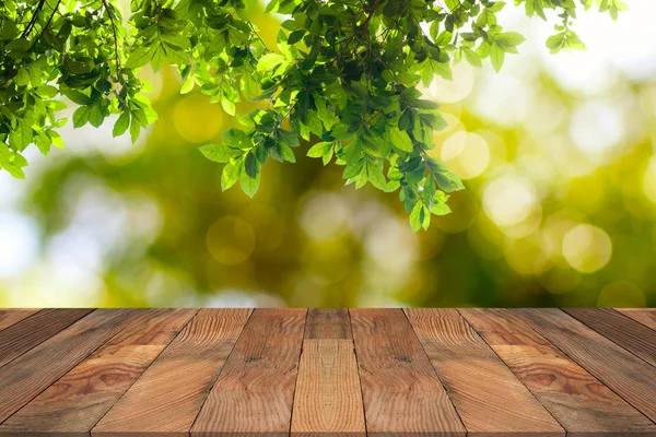 Mesa de madera marrón y hojas verdes colgando con la naturaleza bokeh en b — Foto de Stock
