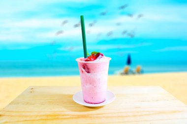 İçki (beyaz çikolata ve çilek) ahşap masa üstünde buz.