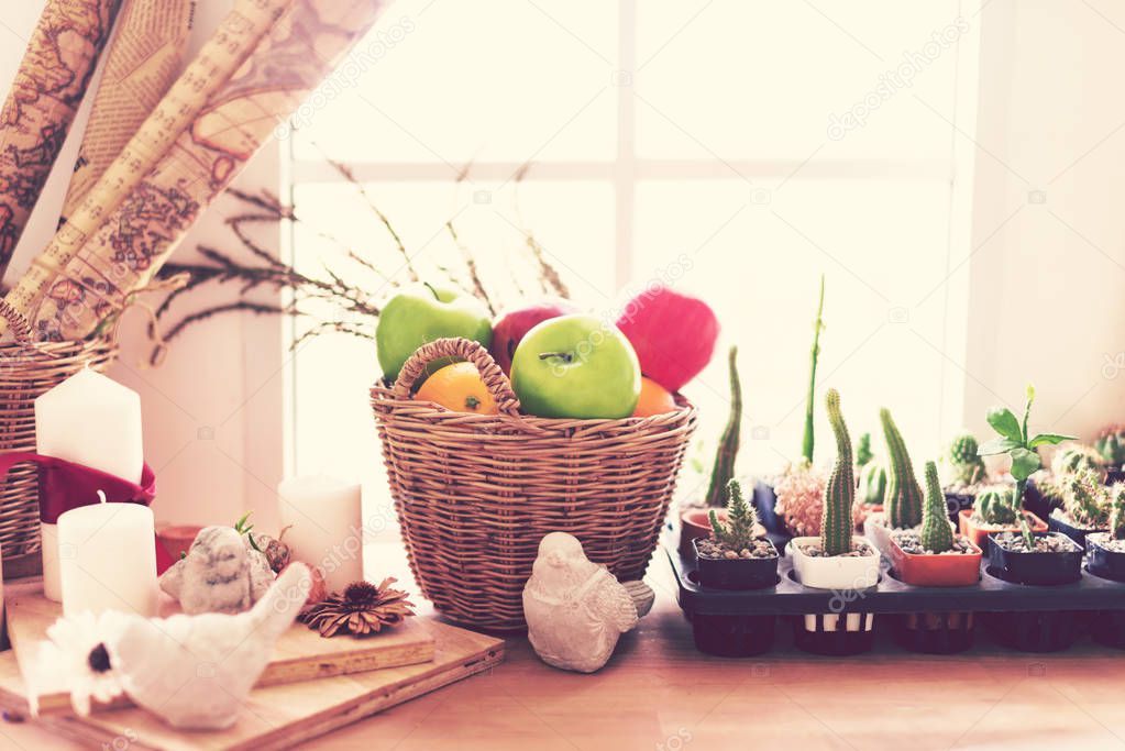 Artificial Fruits in a basket on wood table.