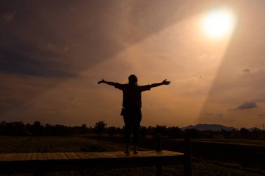 Mutlu bir kadın ayakta silah güneşi görmek.