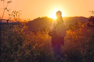 Güneşe bakarak bir kadın backpacker