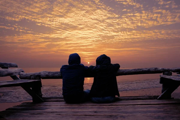 Pasangan bersantai di teras kayu dan mencari Sunrise — Stok Foto