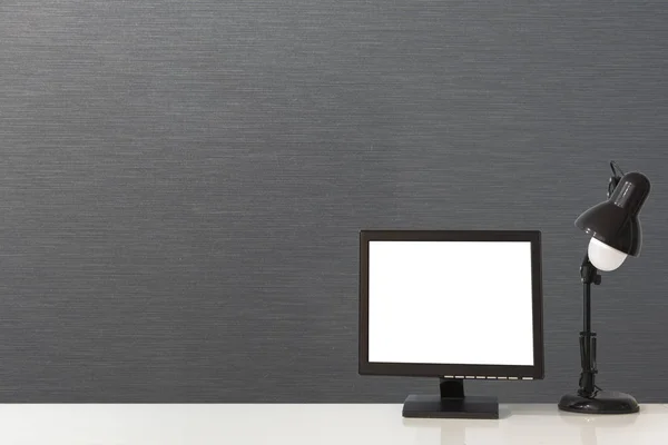 Prázdná bílá obrazovka a elektrická lampa na kancelářský stůl. — Stock fotografie
