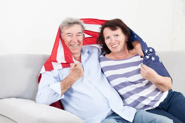 Boldog, ülő vezető pár csomagolva amerikai zászló — Stock Fotó
