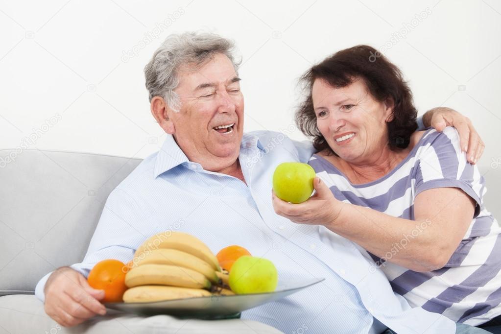 Senior woman offering her husband a green apple