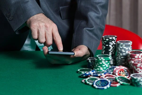 Man holds smartphone, do bet at online casino — Stock Photo, Image