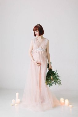 buket çiçek katta beyaz mumlar yanan ile ayakta tutan hamile kadın tam uzunlukta 