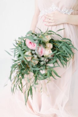  hamile kadın büyük buket çiçek karnı beyaz arka plan üzerinde sandalye üzerinde oturan dokunmadan kırpma