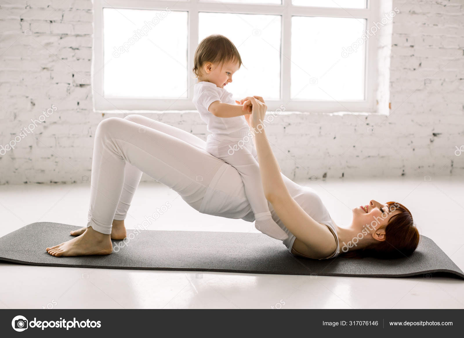 Young happy mother working out, doing butt bridge exercise