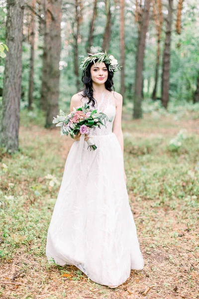 Novia celebración de ramo de bodas en estilo rústico sobre un fondo de bosque de pinos —  Fotos de Stock