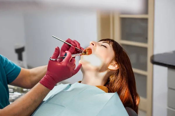 Close up de um homem dentista em luvas médicas vermelhas dando a seu jovem paciente uma injeção de anestesia na clínica dentária — Fotografia de Stock