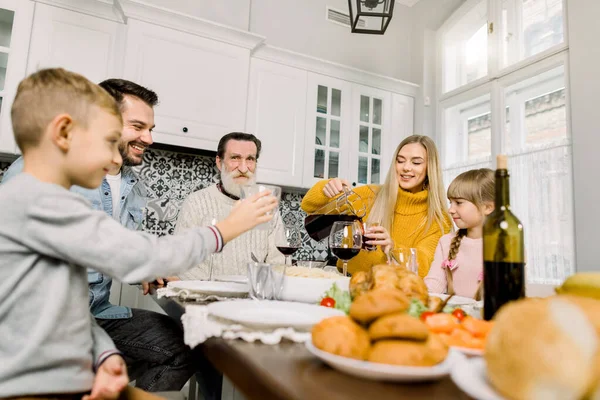 Family having holiday dinner. Pretty young mother pouring cherry juice for her daughter at holiday dinner. thanksgiving day concept — Stock Photo, Image