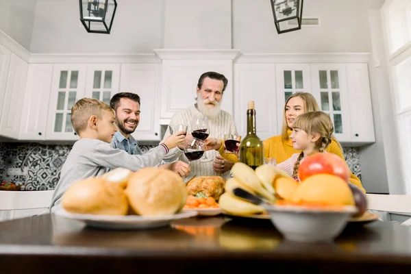 Célébration, vacances et concept de personnes - famille heureuse dîner, boire du vin rouge et griller à la maison — Photo