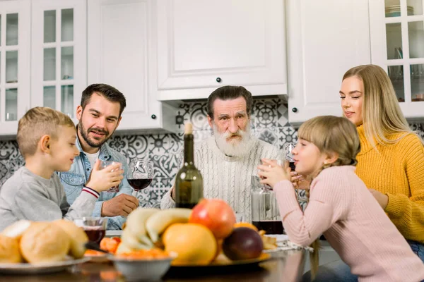 多代家庭庆祝感恩节，一起坐在现代照明餐厅的餐桌前。 爷爷、父母和两个小孩 — 图库照片