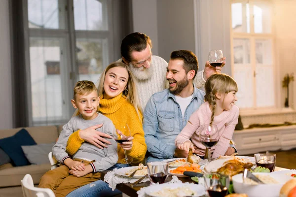 Třígenerační rodina, která spolu večeří doma v obýváku. Rodinná večeře, společně se bavíme — Stock fotografie