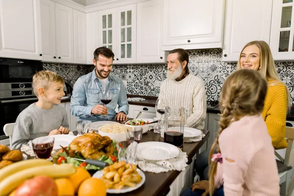 Portrait d'une grande famille assise à une table festive et se regardant, parlant et souriant. Thanksgiving concept de dîner — Photo
