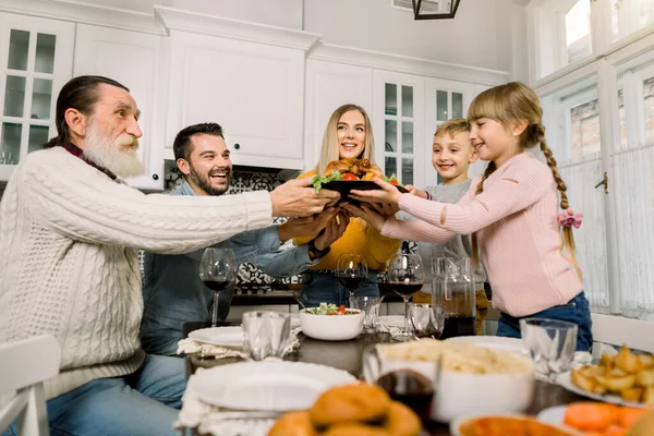 Pretty young woman mother with delicious turkey for holiday dinner with family. Children, father and grandfather are happy and hold their hands on the plate with turkey. Tasty food, dinner — Stock Photo, Image