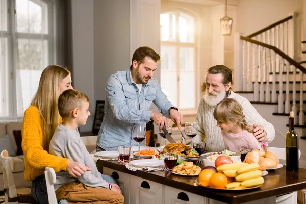 Danksagungsfeier Tradition Familienessen Konzept. Familie beim Urlaubsessen und Vater beim Putenschneiden. — Stockfoto