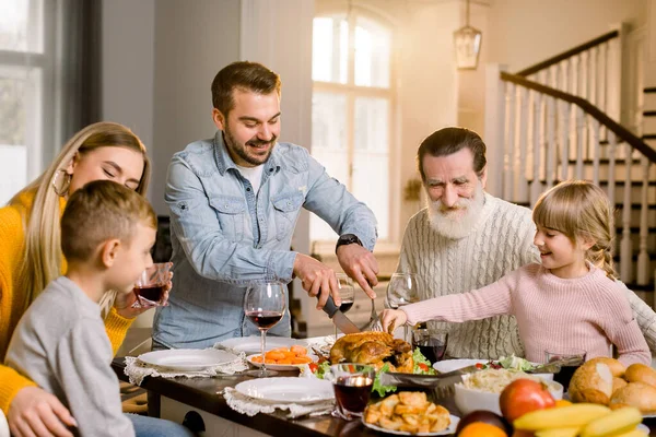 Šťastný vzrušený rodina slaví díkůvzdání při řezání krocana — Stock fotografie