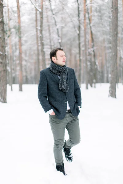 Schöner Hipster-Mann Bräutigam trägt einen eleganten Anzug, steht im schneebedeckten Winter Wald, Ganzkörperfoto — Stockfoto