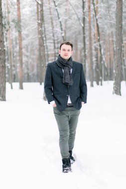 Kış manzaralı şık bir adam. Genç damat kışın dışarıda