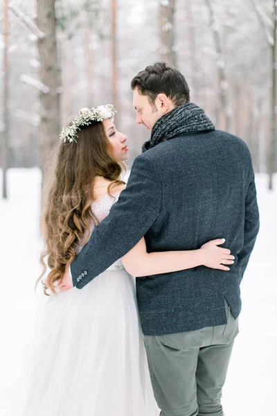 Mariage d'hiver dans la forêt, mariée et marié embrassant, debout et regardant l'autre — Photo