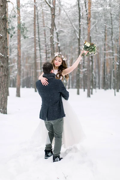 Bröllop i vinterskogen. Pojke och flicka i vinterskogen. Kram kärlek par, man håller kvinna på händer — Stockfoto
