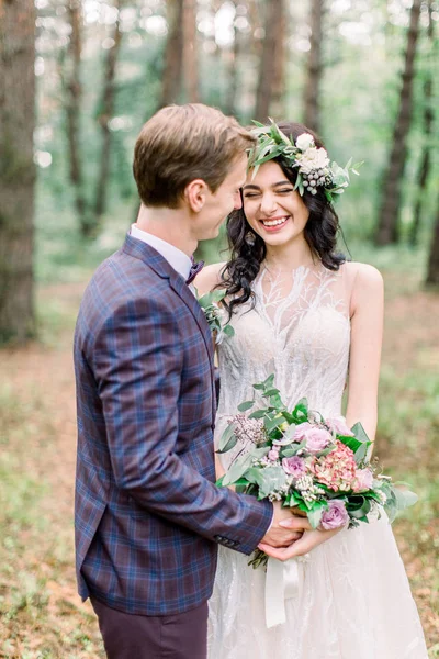 Braut und Bräutigam im Waldkuss. Brautpaar bei einer Hochzeit in der Natur, im grünen Wald, küssen sich und lächeln. Rustikales Hochzeitspaar — Stockfoto