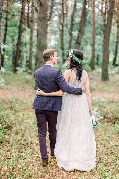 Casal rústico elegante de recém-casados em seu dia de casamento, andando na floresta. Noiva jovem feliz, noivo elegante abraçando — Fotografia de Stock