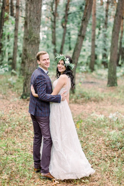 Gorgeous wedding rustic couple hugging, smiling and walking in forest — Stock Photo, Image