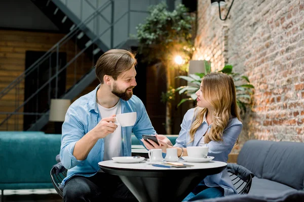 Casal feliz ou amigos flertando conversando e bebendo café em um restaurante ou café ou sala de espera — Fotografia de Stock