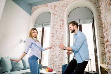 Gündelik giysiler içinde genç ve komik bir çift otel odasında birlikte dans ediyor ve dinleniyorlar..