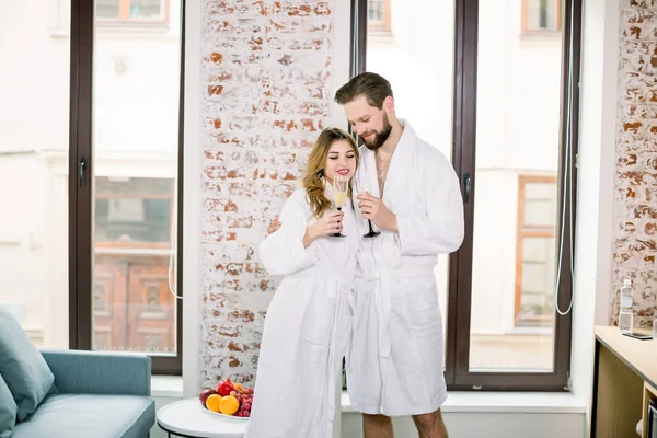 Casal romântico junto com taças de champanhe no quarto do hotel — Fotografia de Stock