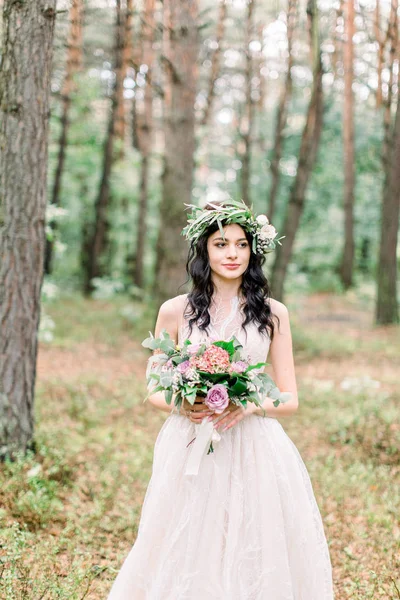 Belle mariée avec bouquet de fleurs en robe blanche se dresse sur fond de forêt. Style rustique — Photo