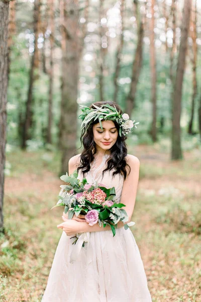 Meravigliosa bruna sorridente sposa con il bouquet di nozze trascorrendo del tempo nella foresta. Ritratto a mezza lunghezza . — Foto Stock