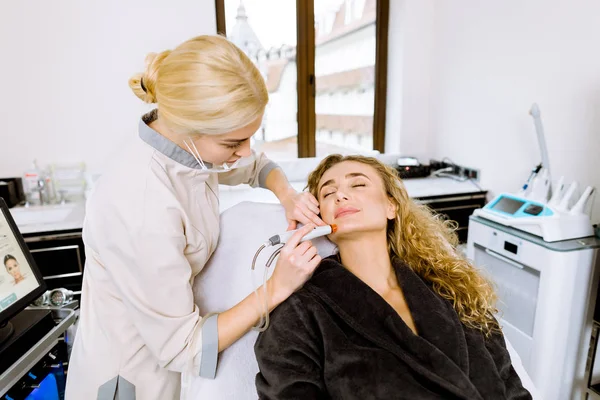 Profesjonalna młoda lekarka kosmetolog robi zabieg hydrauliczny w klinice kosmetologii przy użyciu odkurzacza hydra. Odmładzanie i nawodnienie. Kosmetologia — Zdjęcie stockowe