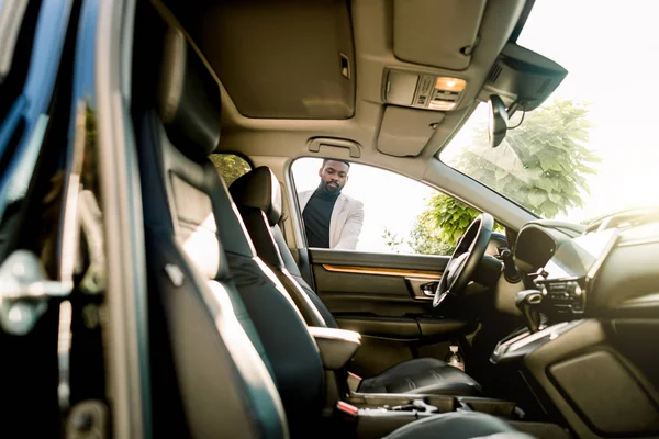 Young african american businessman opening his new car door. Side view, sunny day — 스톡 사진