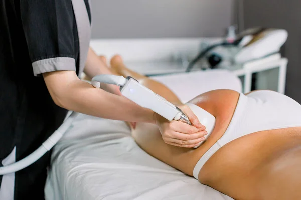 女医生、美容师用女性病人大腿上的器械做滚筒按摩，特写。 医疗温泉中心的滚筒按摩 — 图库照片