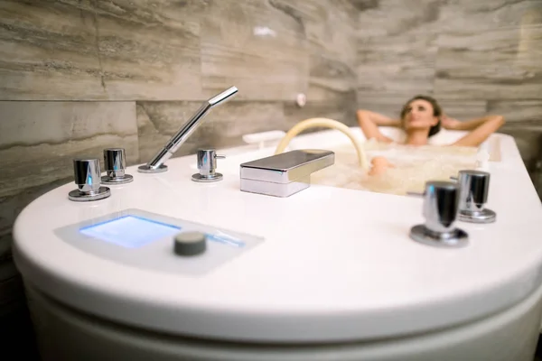 Hermosa mujer relajándose en la bañera teniendo una terapia de hidromasaje. Concéntrate en el baño —  Fotos de Stock