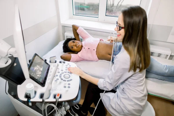 Профессиональное обследование молодых африканских женщин на ультразвуке в современном медицинском центре — стоковое фото