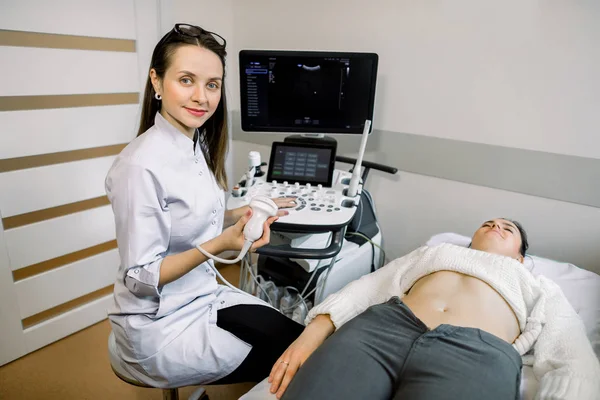 Médica sorridente, conceito de ultra-som. O médico realizou um ultra-som para paciente jovem no centro médico moderno . — Fotografia de Stock