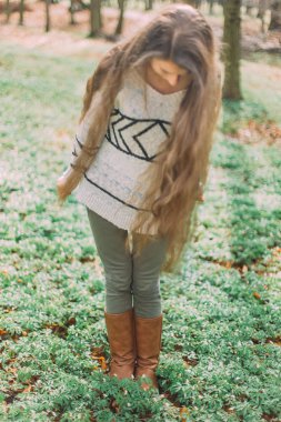 Süveter giymiş güzel bir kadın koşuyor ve sabah yeşil ormanda yürüyor.