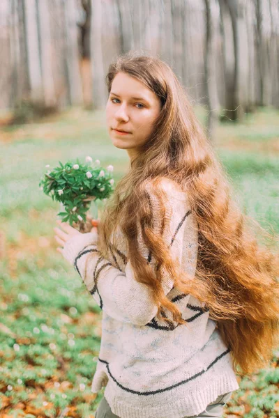 Belle jeune fille femme marche à travers la forêt verte au printemps, tenant ar en verre avec des fleurs blanches de printemps — Photo