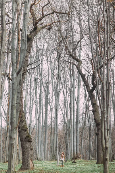 Belle femme en blanc marchant à travers la forêt verte au printemps — Photo