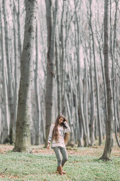 Belle femme en blanc marchant à travers la forêt verte au printemps — Photo